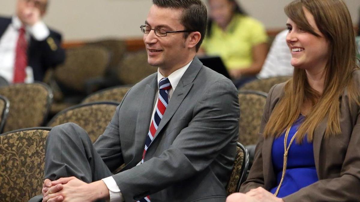 David Altmaier, left, and staffer Caitlin Murray react as Altmaier is confirmed by the Cabinet to be the next insurance commissioner during a meeting, Friday, April 29, 2016, in Tallahassee.
