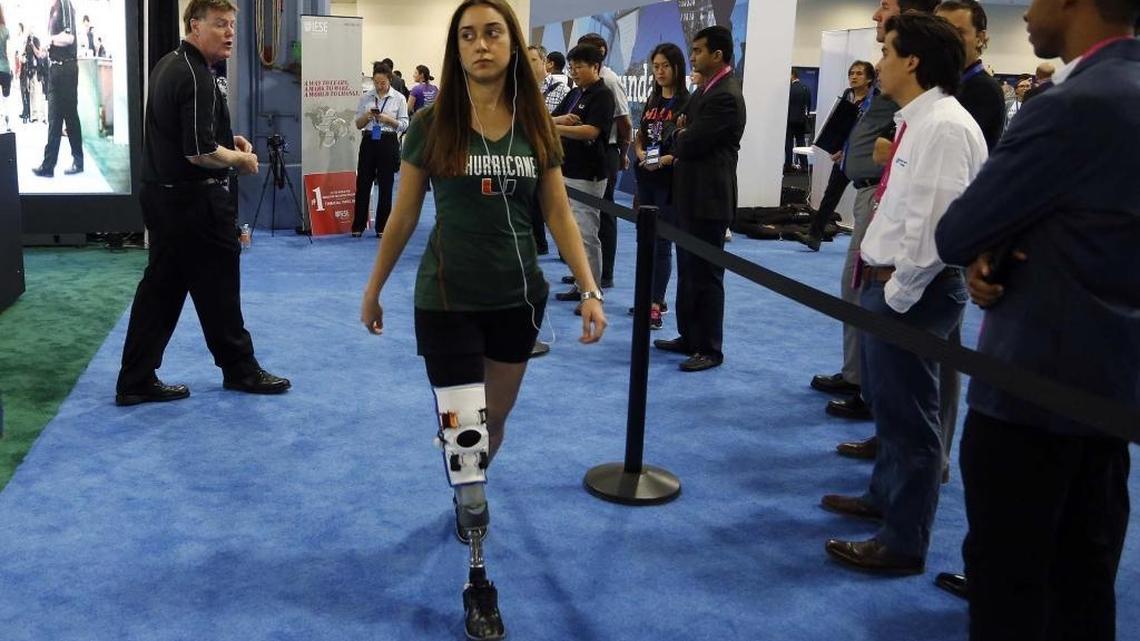 Miami, April 18, 2016 - eMerge Americas opens at the Miami Beach Convention Center. University of Miami Dr. Robert S. Gailey (left) talks as Jennifer Lopez (wearing prosthesis) demonstrates the ReLoad System, ReLoad stands for Rehabilitative Lower-limb Orthopedic Accommodating feedback device. It's a sensor that is attached to a prosthetic and reacts by warping the music being played on the person's cell phone so that whenever the individual wearing the prosthesis doesn't walk properly the sensor warps the music as a means to warn the patient's gait is not correct. It's like having a physical therapist on their phone so that they're constantly being monitored. This constant monitoring will hopefully keep the patient from developing secondary problems such as artrytis or back pains that come.