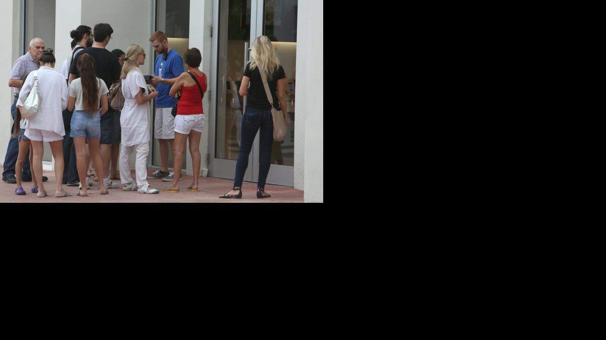
People ask for information about the release of the iPhone 6 at the Lincoln Road Apple store, Thursday, September 18, 2014.
