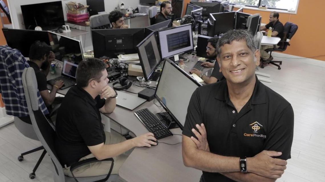 Satish Movva, founder and CEO of CarePredict, poses in front of employees at their headquarters in Plantation, Fla., on Nov. 10, 2017. Health-tech company CarePredict has 17 employees, most of them engineers and data scientists.