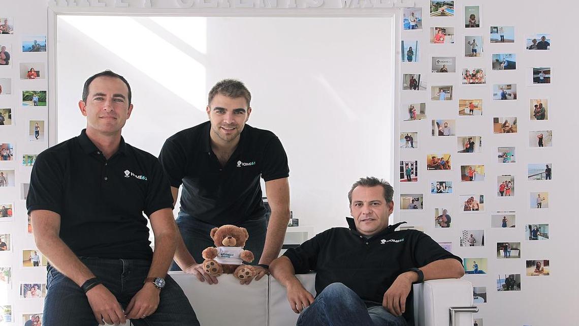 The Home61 management team in the office: Brian Paran, left, Olivier Grinda, center, and Olivier Brion. Photos of their happy clients are on the walls.