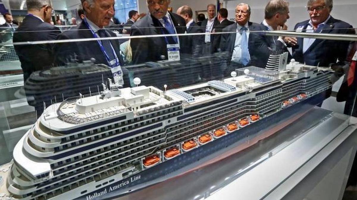 From left, cruise ship executives Vincenzo Petrone and Arnold Donald look over a model of a Holland America Line cruise ship, with David Dingle and Micky Arison, at right, during the Cruise Shipping Miami conference (now Seatrade Cruise Global) at the Miami Beach Convention Center on March 17, 2015.