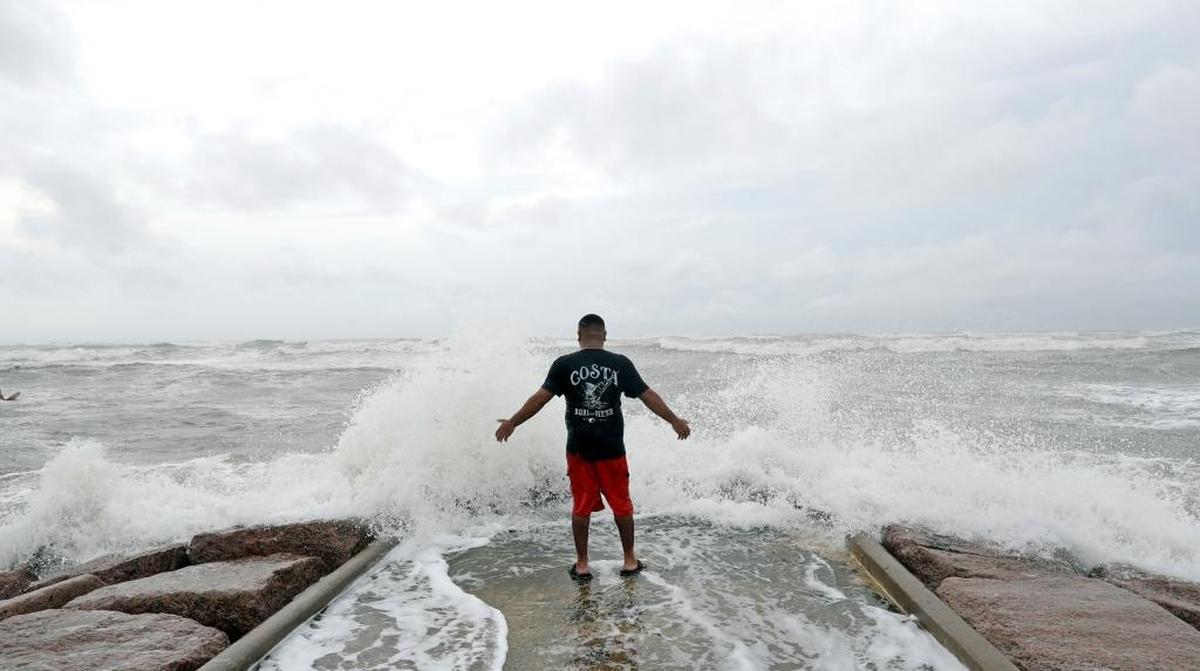 Luis Perez watches waves crash again a jetty in Galveston, Texas as Hurricane Harvey intensifies in the Gulf of Mexico Friday, Aug. 25, 2017. Harvey is forecast to be a major hurricane when it makes landfall along the middle Texas coastline.