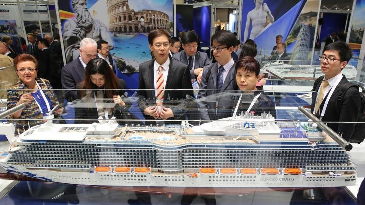 Chinese business group look at ship models at the Fincantieri booth at the Seatrade Cruise Global annual conference in Fort Lauderdale on Tuesday, March 14, 2017