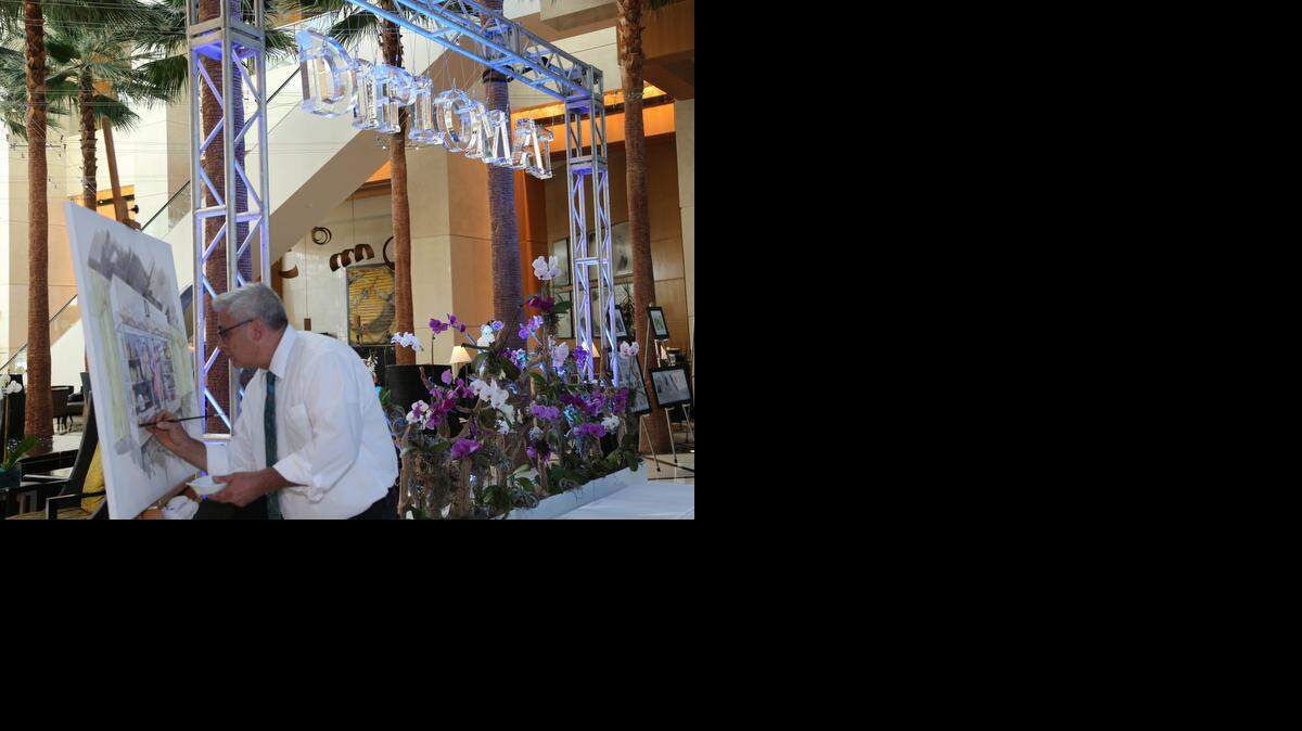 
At an event Thursday, artist Robert Gerdts paints a rendering of a glass Curio that will be installed as a permanent part of Diplomat Resort & Spa.
