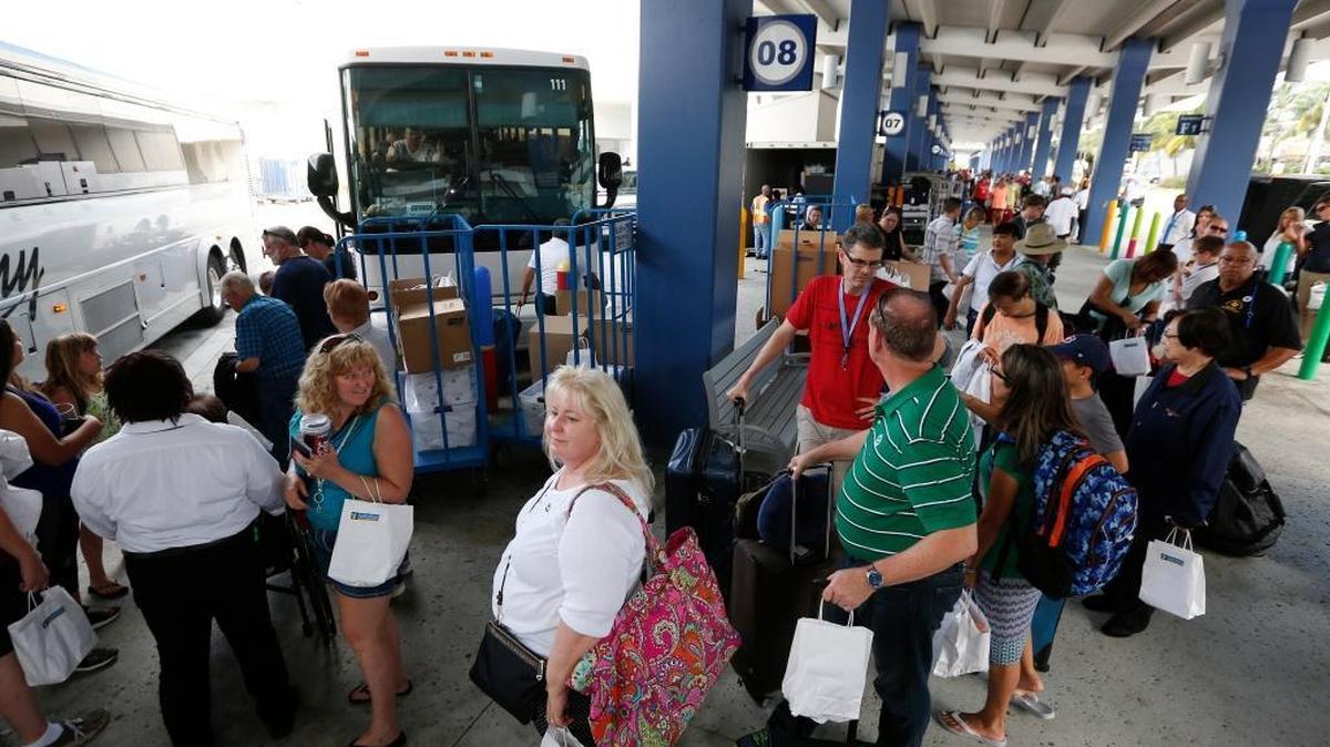 Cruise ship passengers line up for ground transportation after having disembarked from Royal Caribbean International's Liberty of the Seas, Tuesday, Aug. 29, 2017, at PortMiami in Miami. The Galveston, Texas-based cruise ship was scheduled to return to the city Sunday but was diverted to Miami, because of Hurricane Harvey.