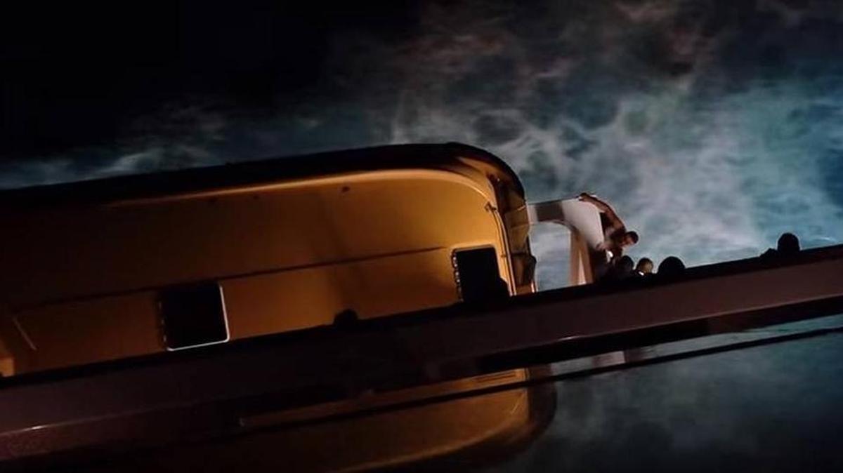 A man clings to a lifeboat after falling off the the Royal Caribbean Oasis of the Seas on Friday, Nov. 6, 2015.