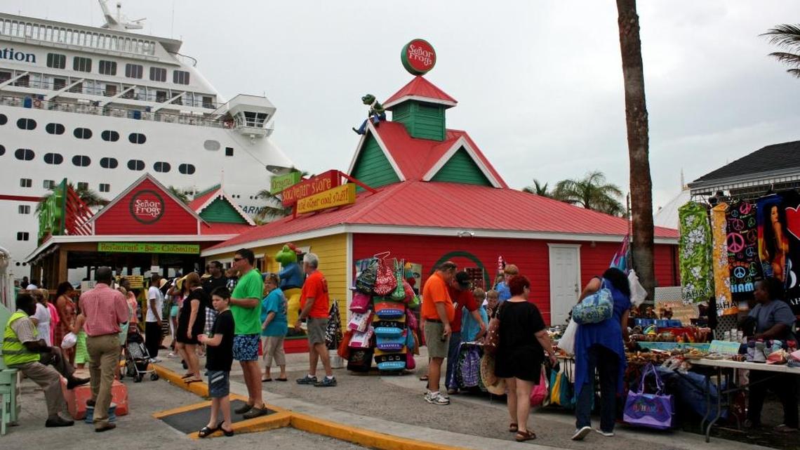 Cruise ship passengers shop at the straw market and stop into Senor Frog's, with the Carnival Fascination in the background, at the cruise ship dock in Freeport, Grand Bahama.