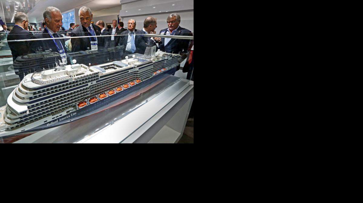 
From left, cruise ship executives Vincenzo Petrone and Arnold Donald look over a model of a Holland America Line cruise ship with David Dingle and Micky Arison at right during the Cruise Shipping Miami conference at the Miami Beach Convention Center on Tuesday, March 17, 2015.
