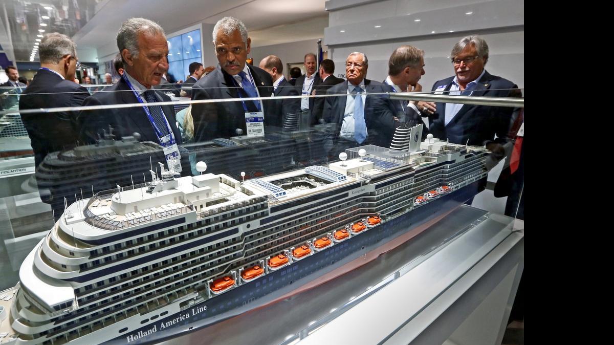 
Carnival Corp. on Monday announced details about four new ships on order. In this file photo from March, Fincantieri chairman Vincenzo Petrone and Carnival Corp. CEO Arnold Donald look over a model of a Holland America Line cruise ship with the company’s David Dingle and Micky Arison seen at right during the Cruise Shipping Miami conference. 
