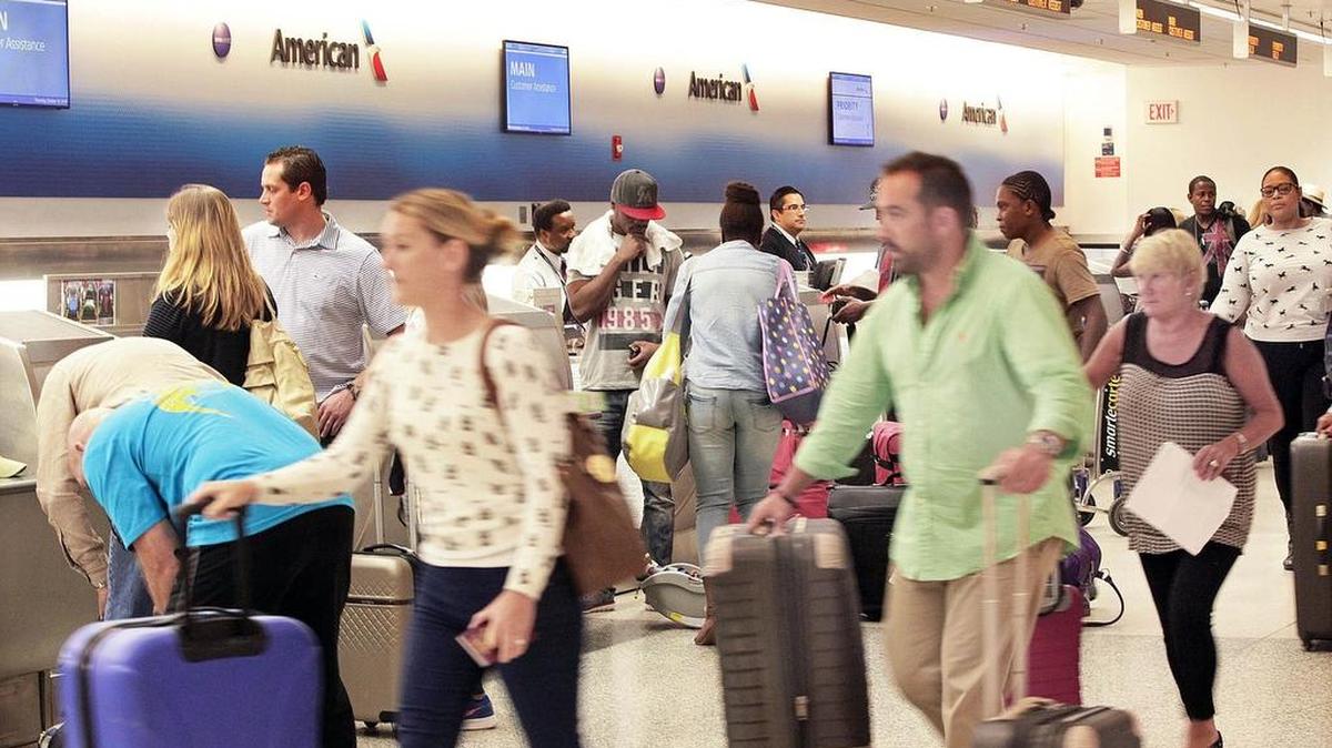 
Travelers bustle past the American Airlines counter on Thursday, Oct. 15, 2015, as the airline prepares its final steps to merge with US Airways.
