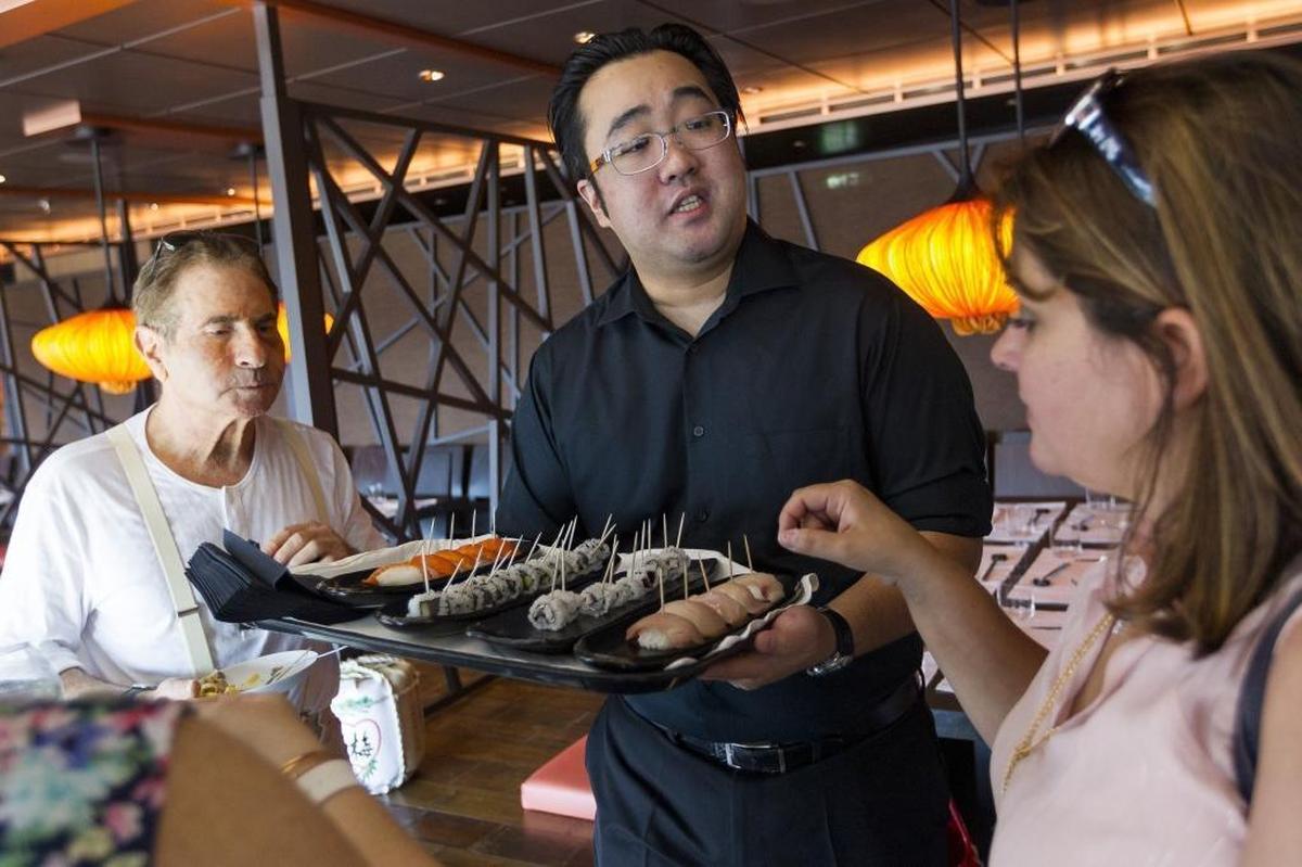 Evin Tsutsui, 29, shares sushi samples with guests at Roy's Restaurant onboard MSC Cruises' newest ship, Seaside.