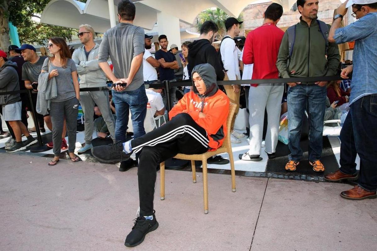 Mathew Sierra, 19, takes a nap after waiting in line at the Apple Store on Lincoln Road in Miami Beach as people lined up to buy the new Apple iPhone X on Nov. 3, 2017.