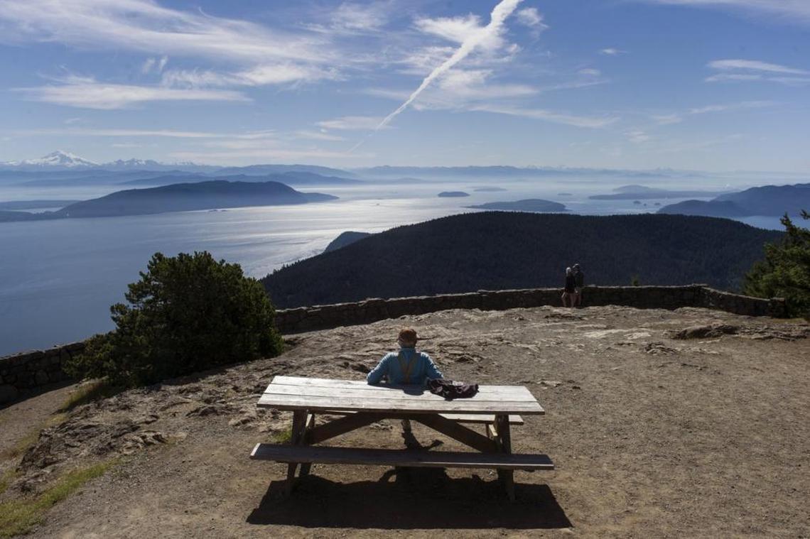 A visitor sits on top of Mount Constitution, part of Moran State Park and the highest point of the San Juan Islands, where Orca Network hopes to one day build Lolita’s seaside sanctuary.