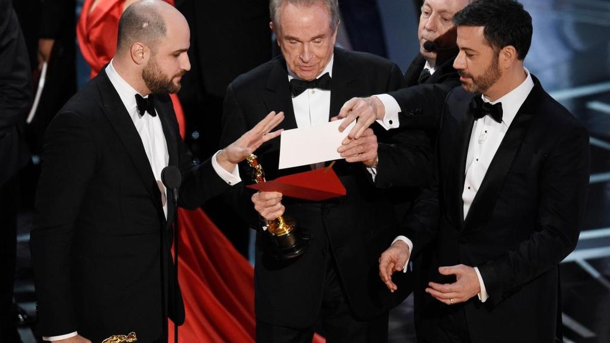 “La La Land” producer Jordan Horowitz, left, presenter Warren Beatty, center, and host Jimmy Kimmel right, look at an envelope announcing “Moonlight” as best picture at the Oscars on Feb. 26 at the Dolby Theatre in Los Angeles. It was originally announced mistakenly that “La La Land” was the winner.