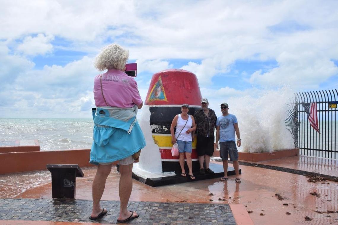 A group of tourists take a photo in front of the Southernmost Point Buoy in Key West on Oct. 5. The landmark, which was badly damaged by Hurricane Irma, was still drawing tourists who wanted to take pictures.