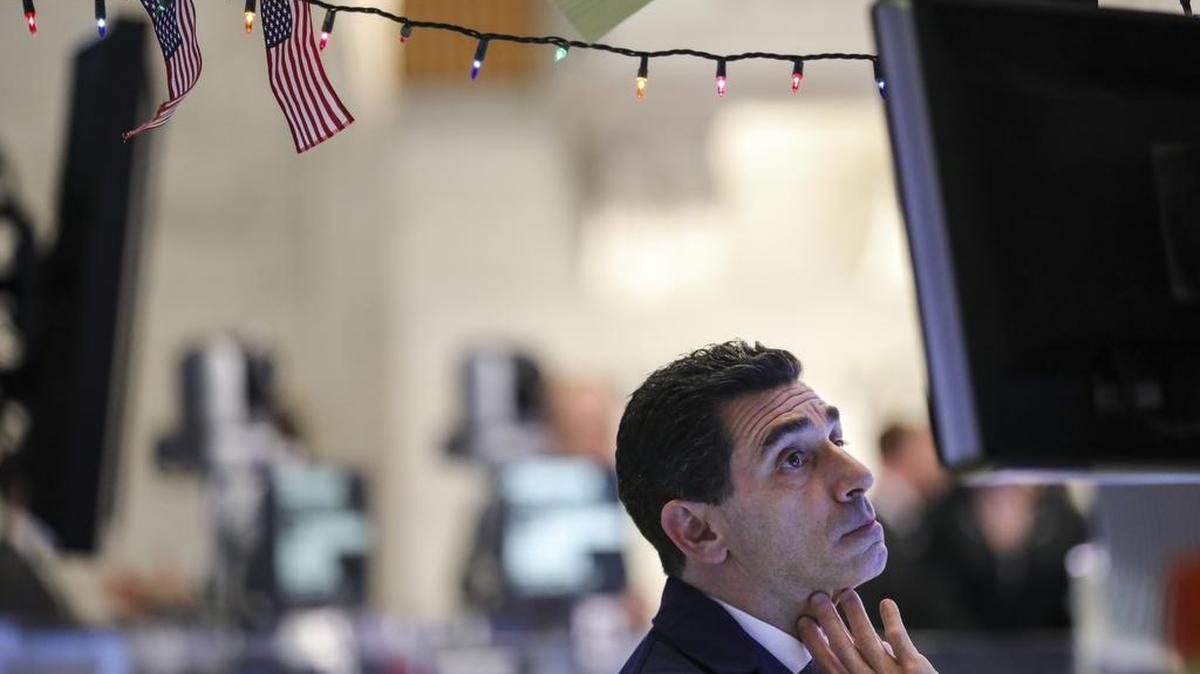 A trader works at his desk ahead of the closing bell on the floor of the New York Stock Exchange on Dec. 17, on a day when the Down was down over 500 points at the close. The traditional wish of investors for a Santa Claus rally between Christmas and New Year’s has been scuttled this year.