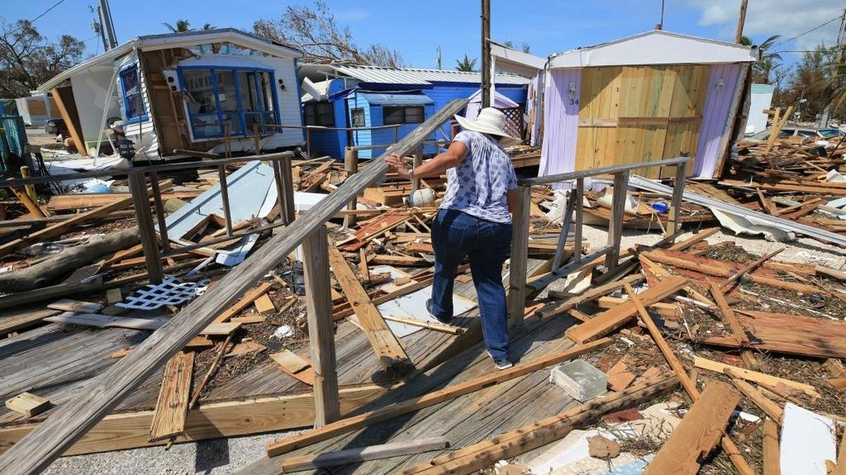 Mirta Mendez walks through debris at the Seabreeze trailer park along the Overseas Highway in the Florida Keys, Tuesday, September 12, 2017.
