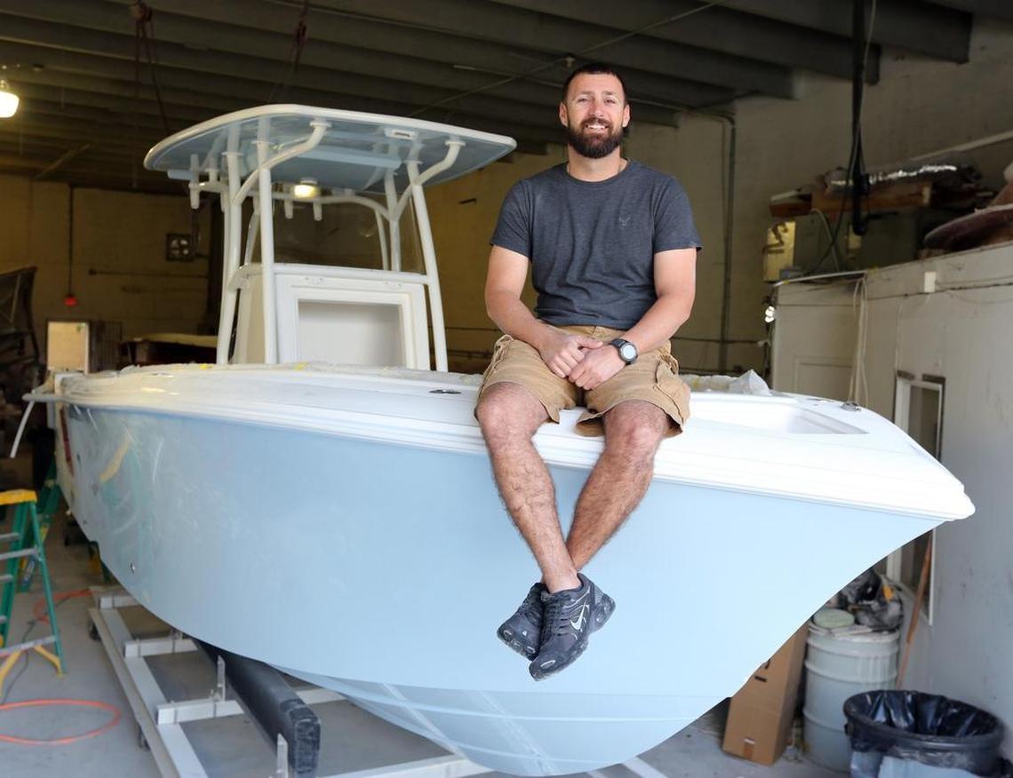 Pedro “Pete” Garcia, vice president of Streamline Boats, sits on the bow of a 26-foot center console being built at the company’s warehouse in Opa-locka.