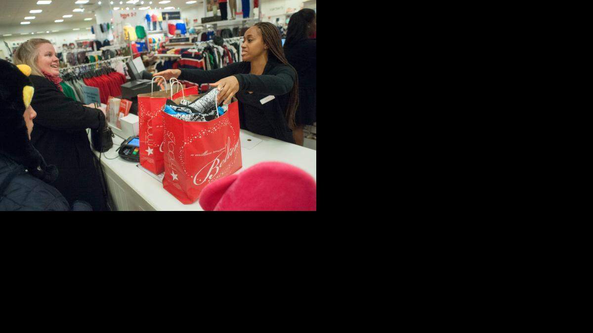 
At Macy's Black Friday opening last year, Wendy Landry, left, stocks up with the children's doorbusters from sales associate Ashley Smith in Atlanta.


