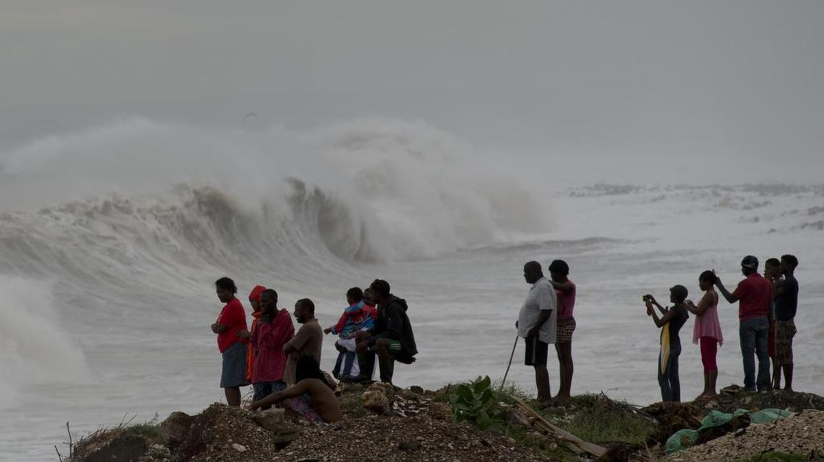 People stand on the coast watching the surf produced by Hurricane Matthew in Jamaica on Oct. 3, 2016. Natural disasters are one of the challenges small Caribbean economies face on a fairly regular basis.