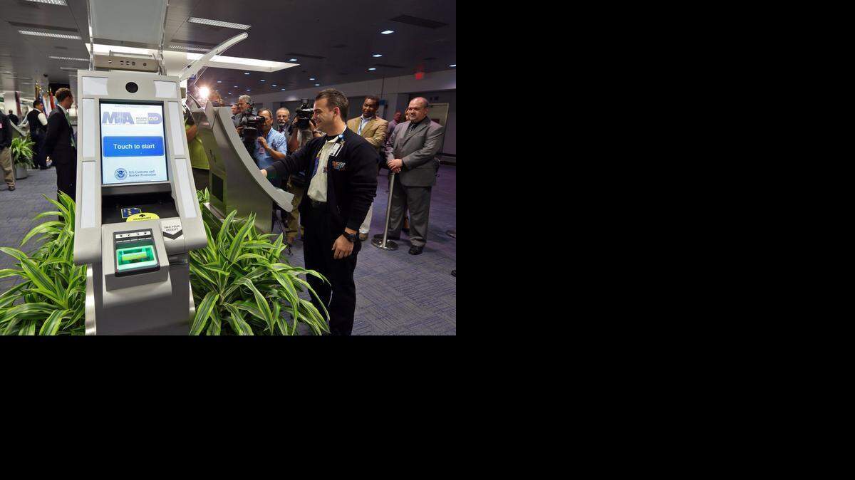
MIA Operations Specialist Dayron Rodriguez demonstrates passport kiosks at Miami International Airport’s Terminal D in this 2013 file photo. 
