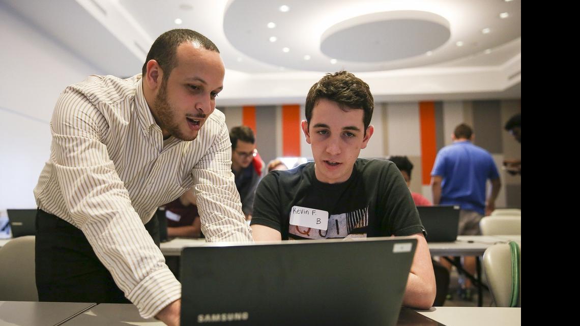 
Instructor Daniel Taveras, 27, helps Kevin Fitzpatrick, 17, of Archbishop McCarthy High School, create an app at the Samsung Mobile App Academy at the University of Miami on Thursday. Fitzpatrick is one of 60 South Florida high school students selected to attend the weeklong academy. He is building a CPR assistant app that will help regular citizens decide the best steps in an emergency situation. Fitzpatrick thought of the idea after recently becoming CPR certified.
