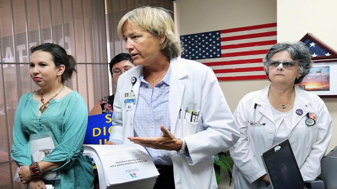 In this May 2015 photo, Martha Baker, a trauma nurse and president of SEIU 1991 at Jackson Health Systems, holds 13,000 signatures that she turned in to State Rep. José Oliva at his office in Hialeah. On the left is patient Isabel Betancourt and on the right is Dr. Alina Valdes. Baker spoke Wednesday in Miami to advocate that Florida expand eligibility for Medicaid to nearly all low-income adults.