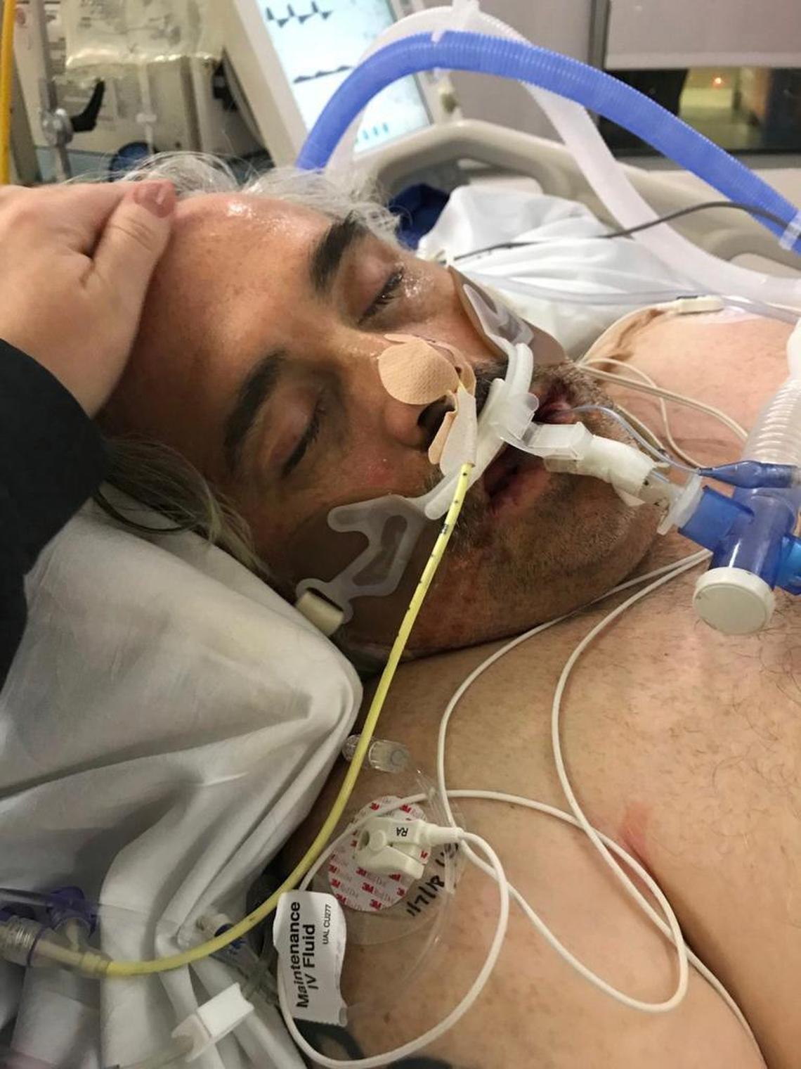 This January 2018 photo provided by Jennifer Burrough shows Shawn Burrough in the hospital in San Diego. Jennifer Burrough and her family didn’t get flu shots this year after hearing reports that suggested it might not work very well this season. But her 48-year-old Navy veteran husband, Shawn, landed in the hospital and he had trouble breathing and his kidneys started shutting down. He was medically sedated and put on a breathing machine.