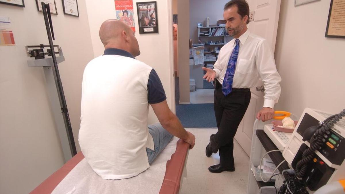 In this photo from May 23, 2007, Dr. Bernd Wollschlaeger, a primary care physician, meets with a patient. The doctor operated a primary care practice in North Miami Beach without taking insurance.