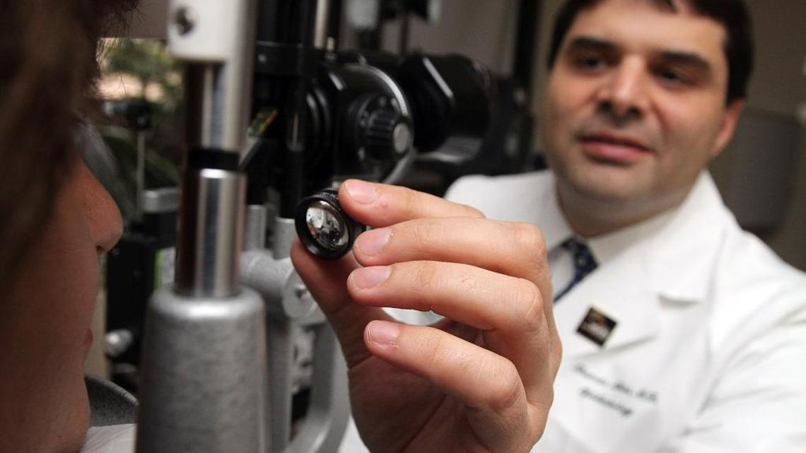 In this 2012 photo, Dr. Thomas Albini, a professor of clinical ophthalmology at Bascom Palmer Eye Institute, demonstrates an eye exam used on patients to detect signs of macular degeneration. Albini co-wrote an article in this week’s New England Journal of Medicine about three women blinded after receiving stem cell injections at a Broward clinic to treat their macular degeneration.