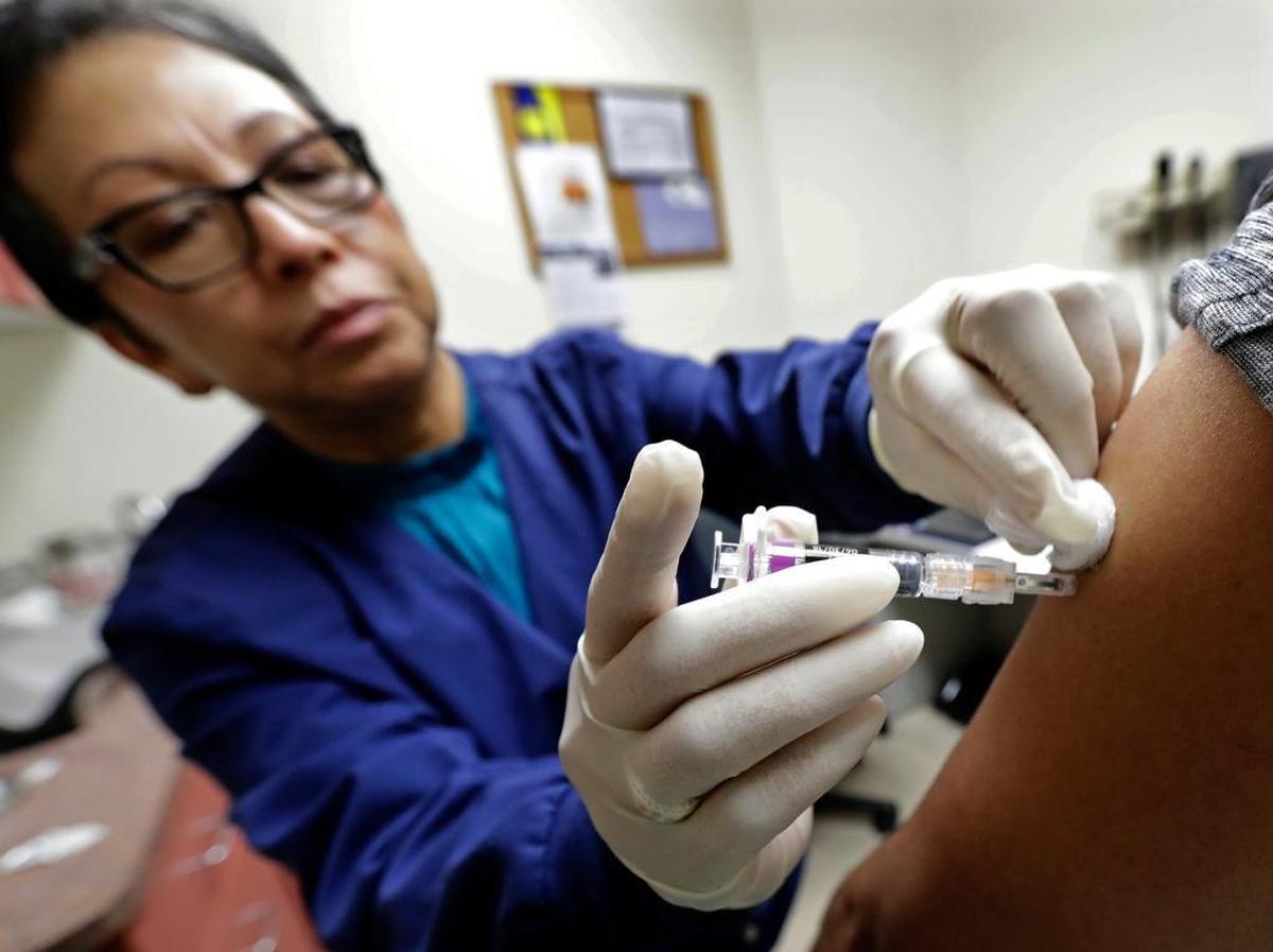Don’t be a baby. A flu shot doesn’t hurt that bad and it won’t give you the flu. But it might prevent or lessen the severity of one. This Jan. 11, 2018, file photo shows Ana Martinez, a medical assistant at the Sea Mar Community Health Center, giving a patient a flu shot in Seattle.