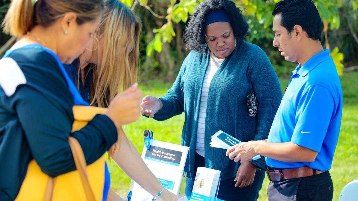 Florida Blue representative Marco Merino (Right) speaks with consumers at Miami Dade College’s Kendall campus on Oct. 25 about open enrollment for Affordable Care Act coverage, which begins on Nov. 1. Many consumers are confused and uncertain about the status of the health law known as Obamacare — leading Florida insurers, enrollment counselors and advocates to gear up outreach efforts.