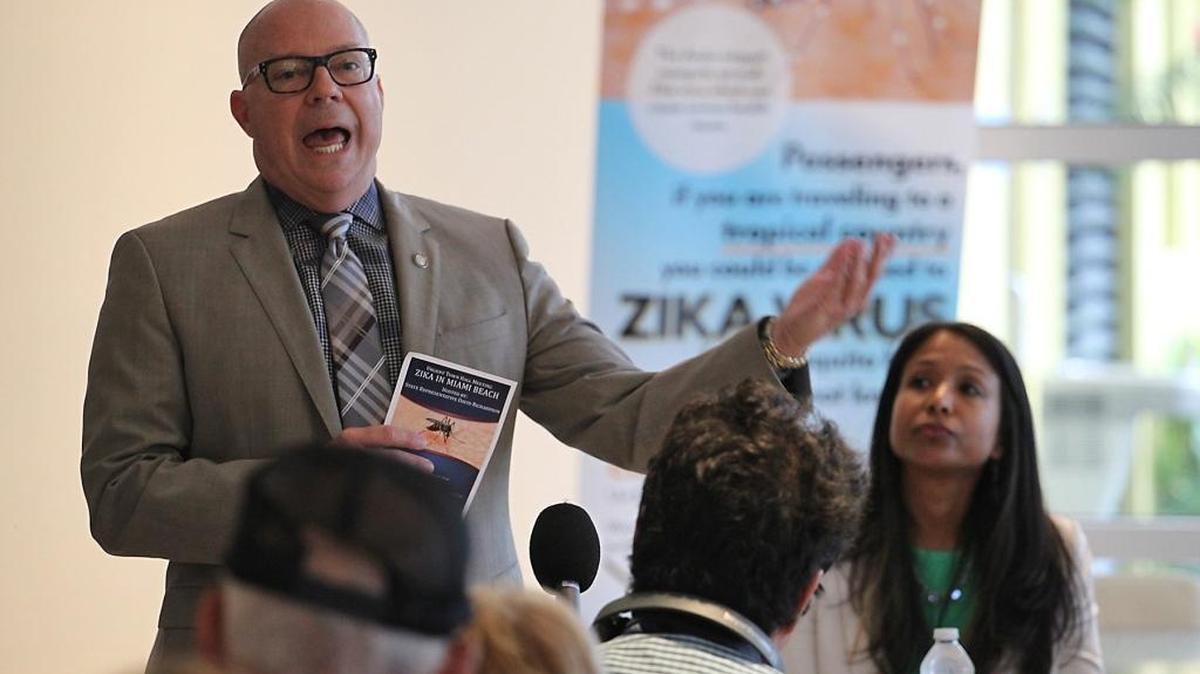 State Rep. David Richardson talks to a crowded room, as Florida Surgeon General Celeste Philip looks on, during a town hall meeting called by State Rep. David Richardson on Monday in South Beach to talk to the community about Zika virus.