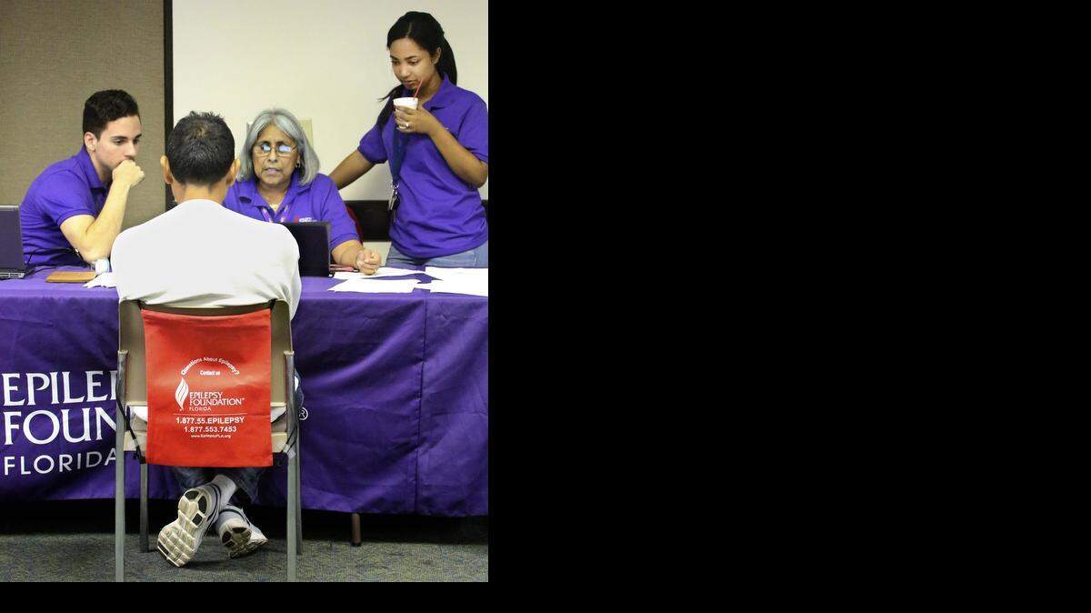 
From left, Ever Quinones, Juanita Mainster, and Sarai Mercado, certified navigators for the Epilepsy Foundation of Florida, assist a man in signing up for health coverage under the Affordable Care Act on Saturday morning, Nov. 15, 2014 at Palmetto General Hospital in Hialeah.
