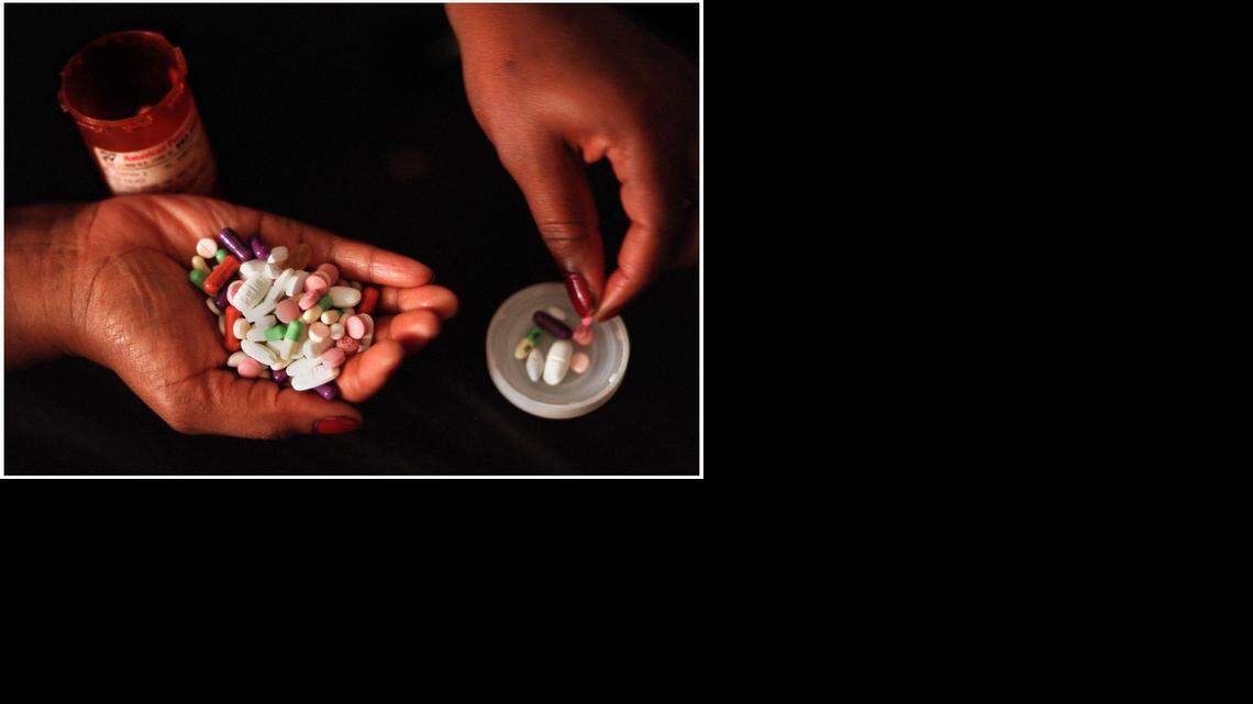 
A patient holds her regimen of HIV/AIDS drugs.
