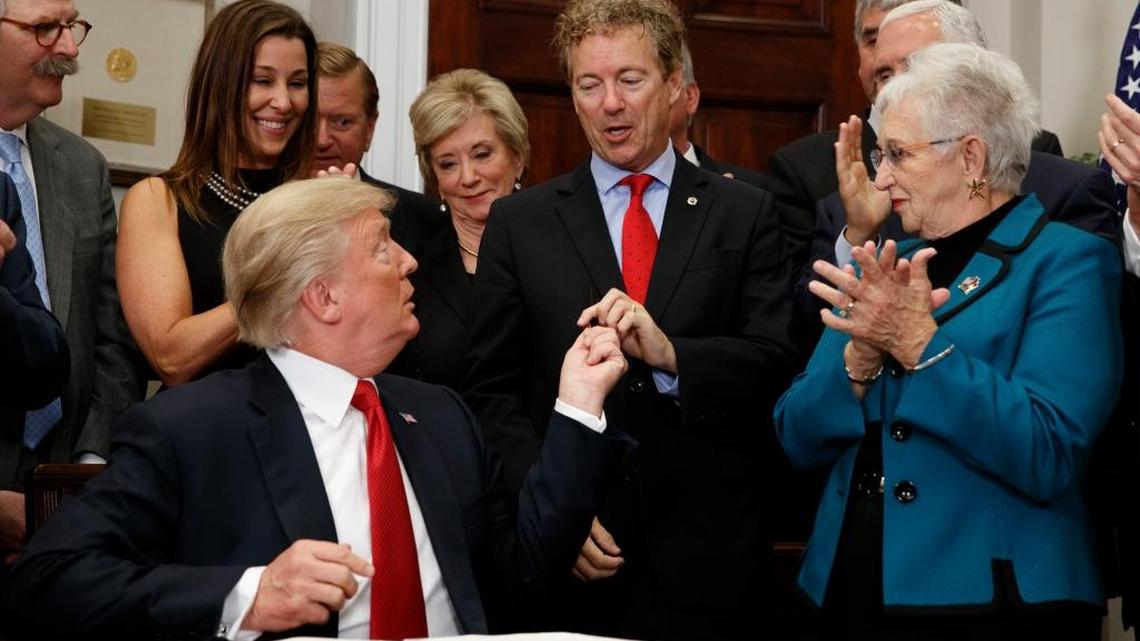 President Donald Trump hands a pen that he used to sign an executive order on health care to Sen. Rand Paul, R-Ky., in the Roosevelt Room of the White House, Thursday, Oct. 12, 2017, in Washington.