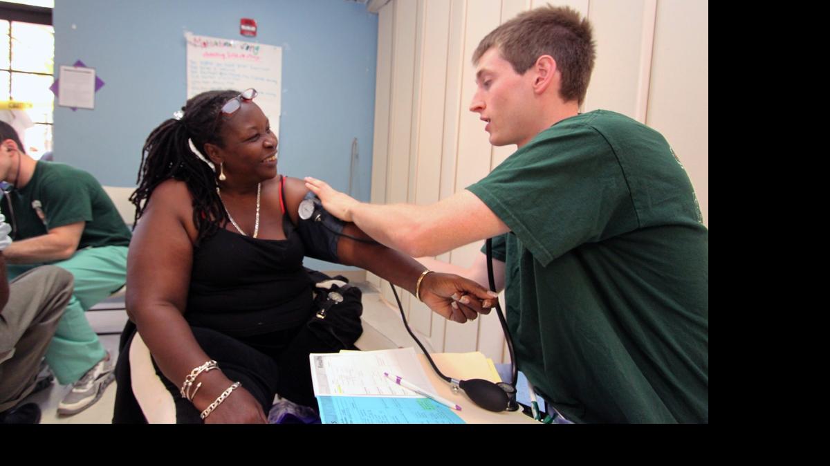 
Yvette Phillips, of Miami, has her blood pressure taken by University of Miami medical student Daniel Nelson at an event in Liberty City last year that offered free services to residents.
