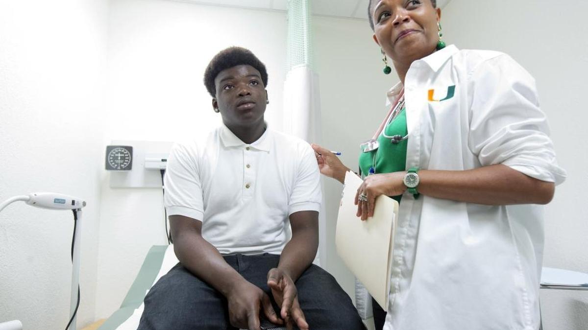 In this Tuesday, Aug. 19, 2014 photo, Dr. Marie-Denise Gervais talks to Amos LeClerc as she performs an examination on him at a clinic in a Miami high school. More than 50 percent of Florida’s Medicaid recipients are under the age of 18, according to state officials. This month, the Florida Legislature learned that private insurers managing care for Florida’s estimated 4 million Medicaid beneficiaries were underpaid about $433 million over the past two years. The underpayments will repaid by federal and state officials, with Florida responsible for about $173 million.