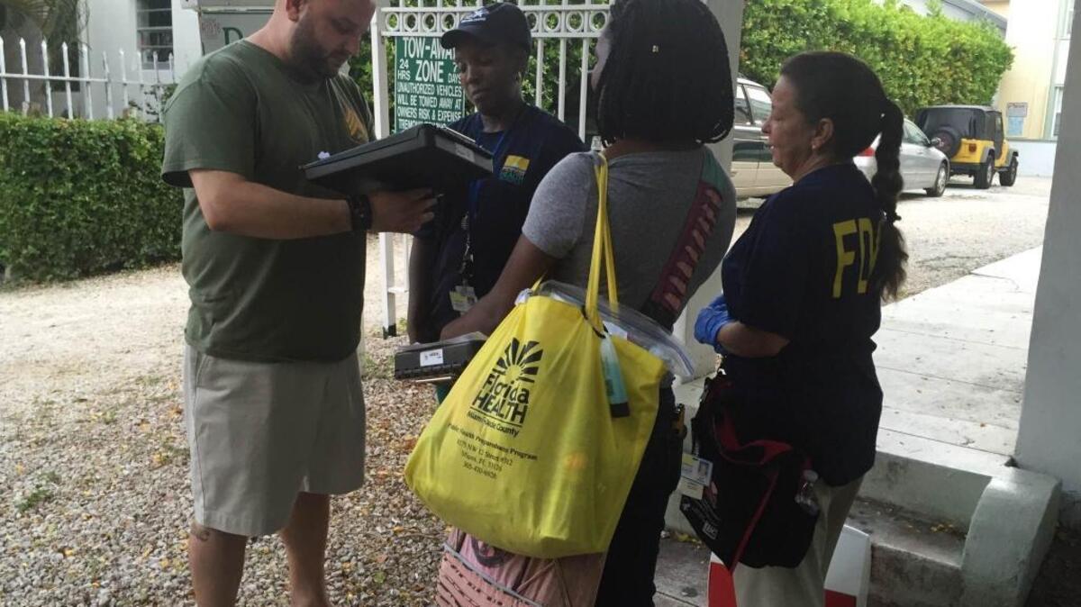 Mariano Corcilli fills out a survey for Department of Health workers who were canvassing his neighborhood Wednesday to talk to residents about Zika virus.