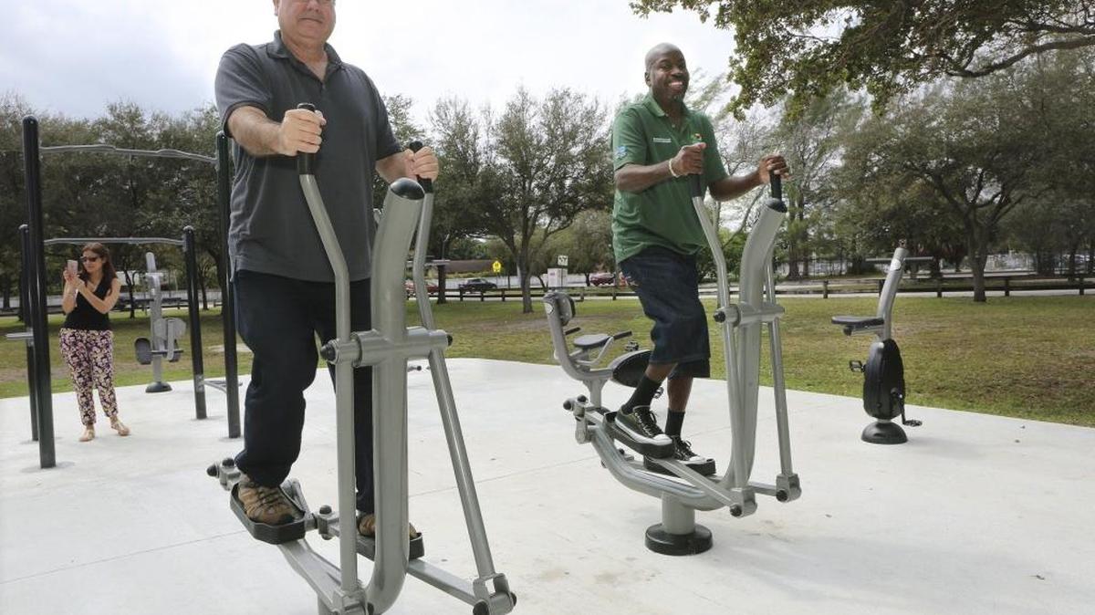 David Livingstone, left, and Mitch Burroughs, employees of Miami-Dade’s parks department, use the elliptical machines at Miami-Dade Parks' new Fitness ZoneAE outdoor gym in Aventura. Easy access to exercise opportunities helped boost Miami-Dade’s health rankings in a national report released March 16.