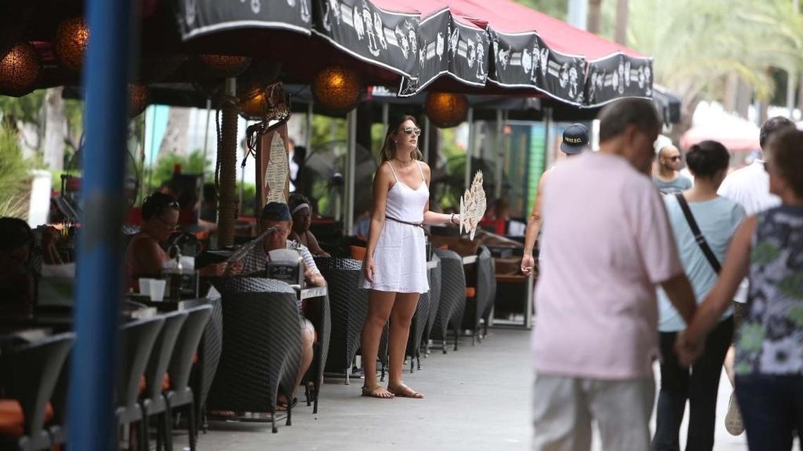 A hostess at an eatery on Lincoln Road, tries to get people to come to her restaurant during lunch on the Tuesday after Labor Day, Sept. 6.
