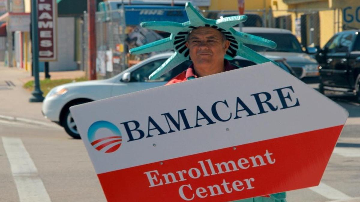 A man dressed as the statue of liberty advertises for an Affordable Care Act enrollment center on a Little Havana sidewalk in 2015. Open enrollment for the ACA exchange begins Tuesday and runs through January, though consumers need to sign up by Dec. 15 for coverage to begin on Jan. 1, 2017.