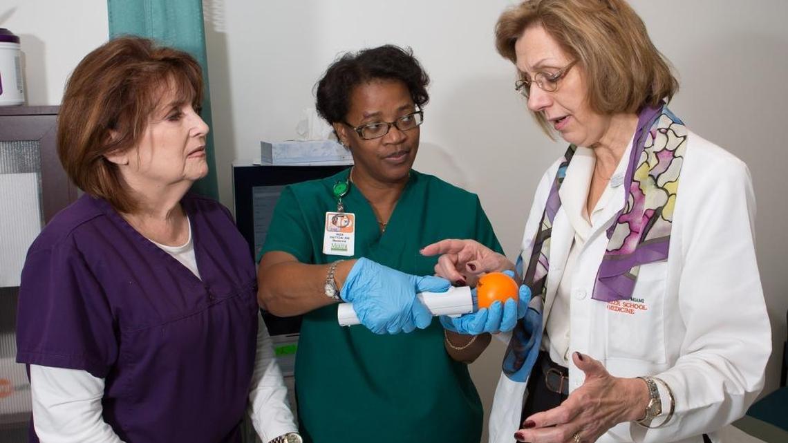 Margaret Fischl, an infectious disease physician and scientist with the University of Miami Health System and Miller School of Medicine, and UM clinical research nurses demonstrate the needle-free injector that will be used to administer an experimental Zika vaccine in a Phase 2 trial led by the National Institutes of Health. Vaccinations have begun in Miami, Houston and Puerto Rico as part of a clinical trial testing an experimental DNA vaccine designed to protect against disease caused by Zika.