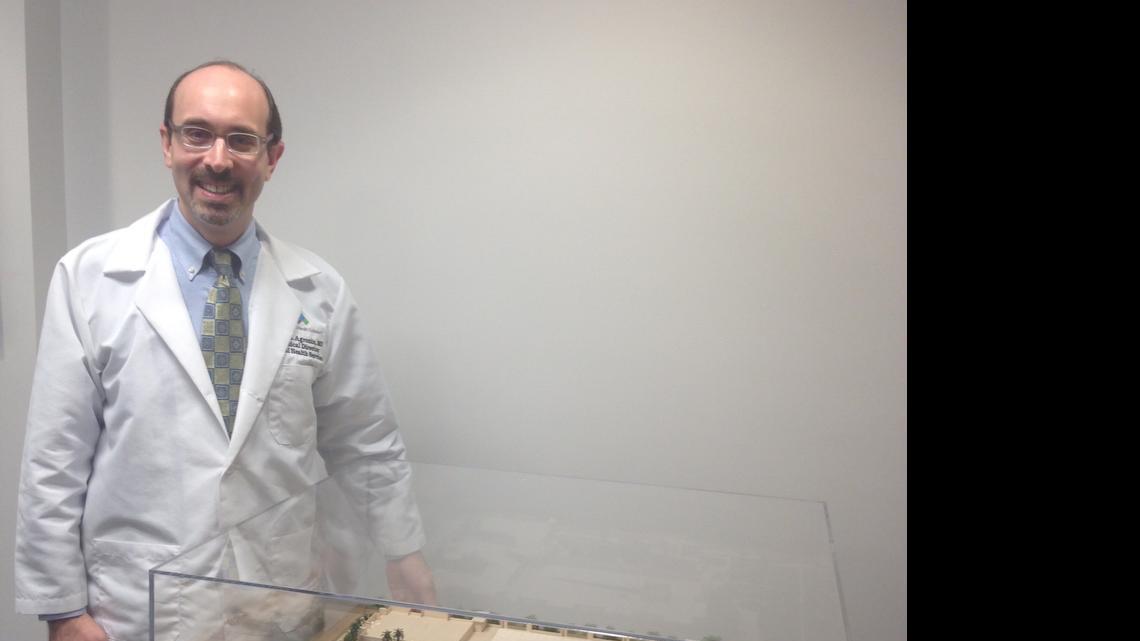 Dr. Marc Agronin stands next to a model that shows the planned expansion of Miami Jewish Health Systems