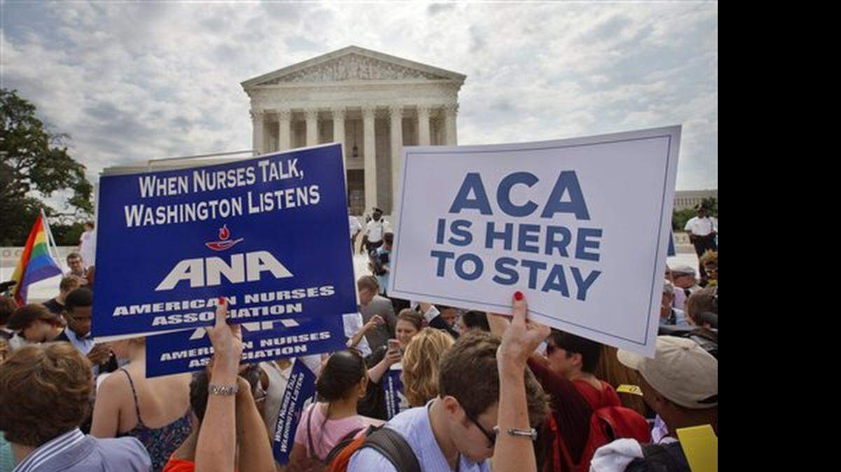 Supporters of the Affordable Care Act hold up signs as the opinion for health care is reported outside of the Supreme Court in Washington, Thursday June 25, 2015. The Supreme Court on Thursday upheld the nationwide tax subsidies under President Barack Obama's health care overhaul, in a ruling that preserves health insurance for millions of Americans. The justices said in a 6-3 ruling that the subsidies that 8.7 million people currently receive to make insurance affordable do not depend on where they live, under the 2010 health care law.