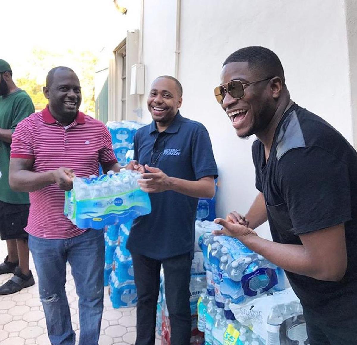 BMe Community cofounder Benjamin Evans, with community members Jonathan Spikes and Mario Bailey (left), distribute donated water at a Hurricane Relief breakfast in Broward County organized by State Rep. Shevrin Jones.
