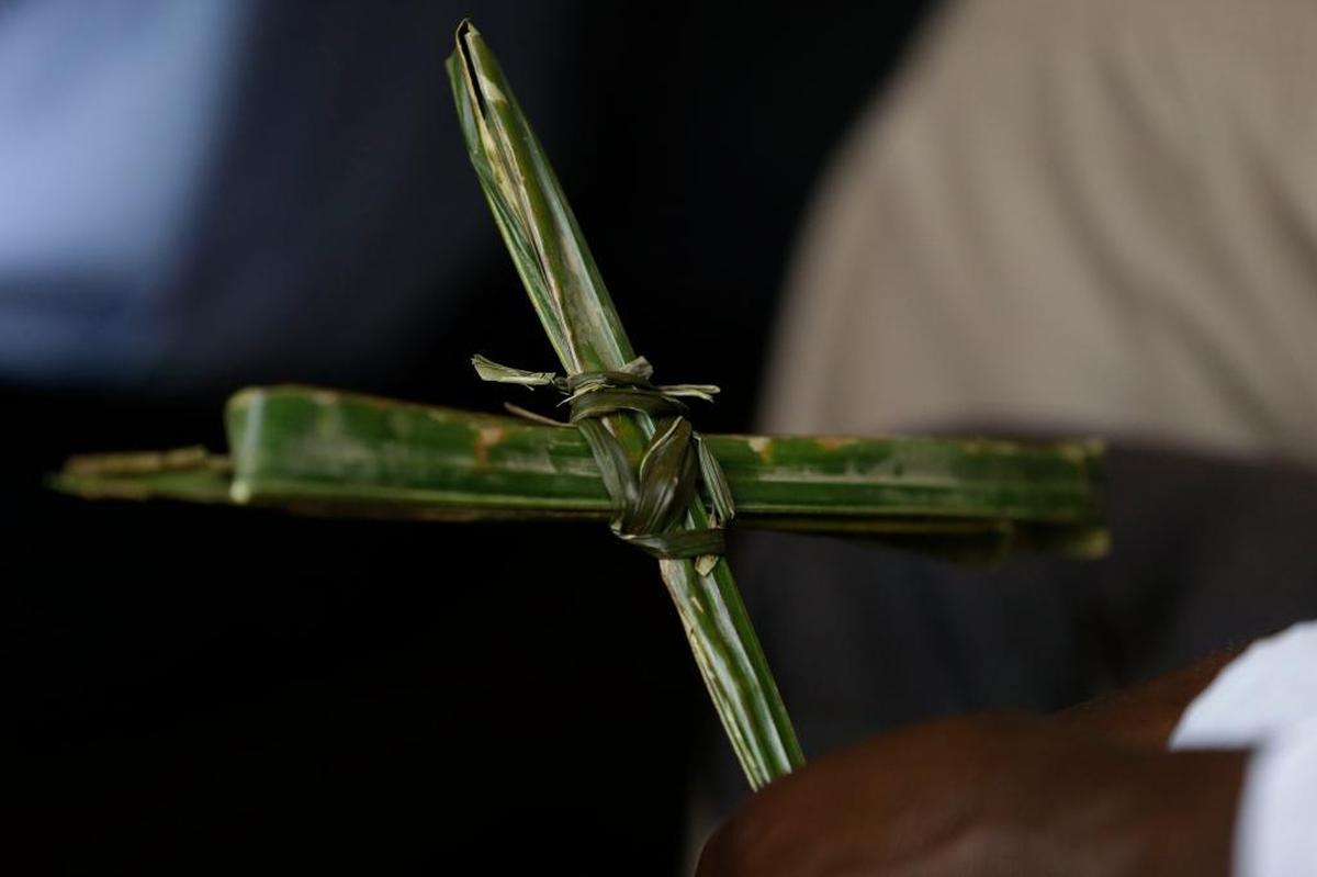 A Nigerian holds a cross made out of a palm leaf, during Palm Sunday mass at St Theresa's Catholic Church, in Yola, Nigeria. Sun., March 29, 2015.