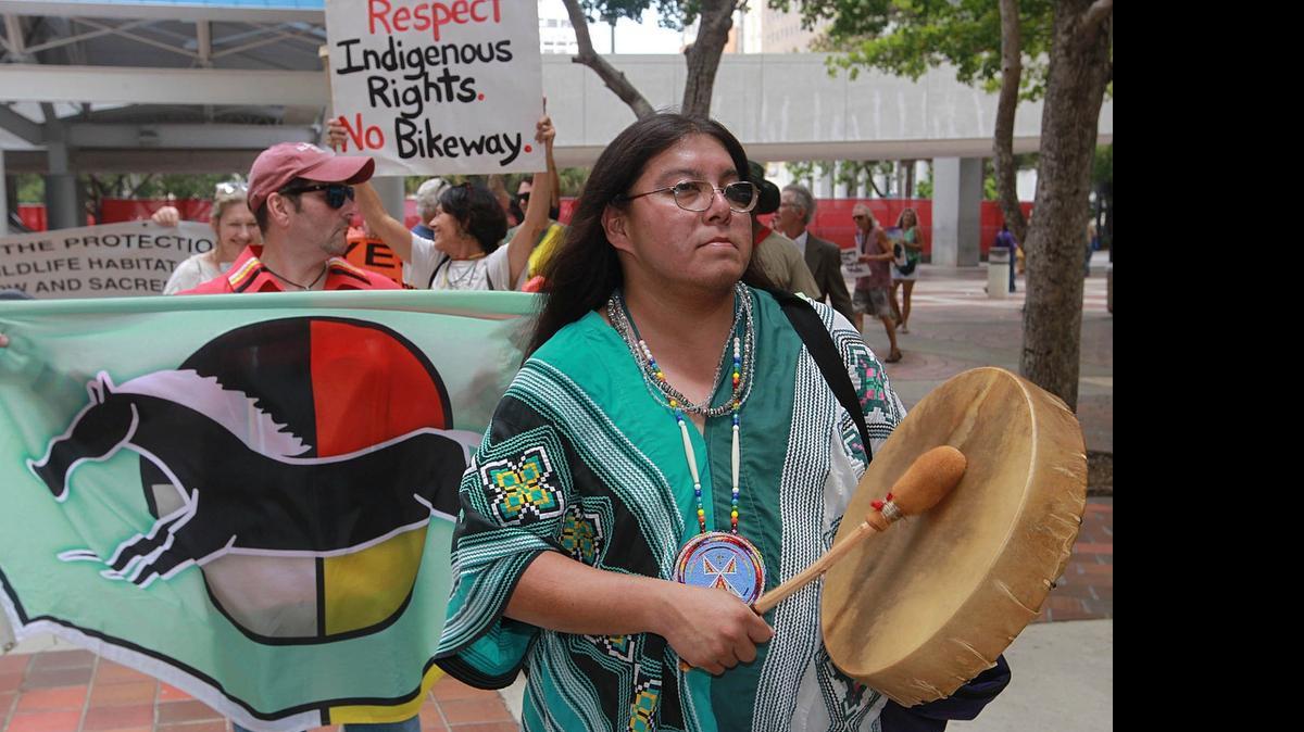 
Houston Cypress, center right with drum, a Miccosukee tribe member and other critics of a bike trail across the Everglades, protested Monday in downtown Miami.

