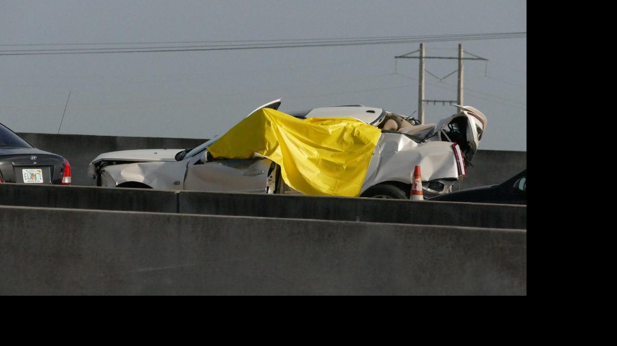 
A tarp covers a car involved in a fatal crash on westbound I-595 west of I-95 and a east of US-441. Traffic slowed in both directions of I-595 and in the area as a whole on Thursday morning June 11, 2015.

